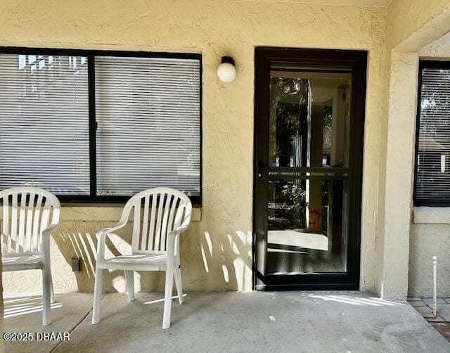 view of exterior entry featuring a patio