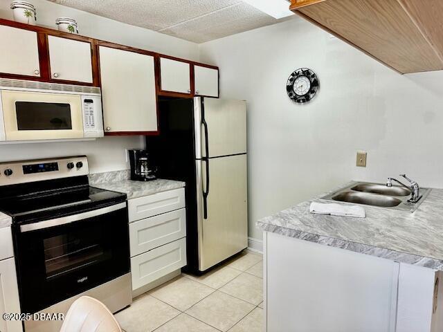 kitchen featuring white cabinetry, appliances with stainless steel finishes, sink, and light tile patterned floors