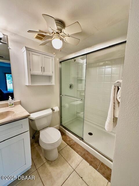 bathroom with ceiling fan, vanity, tile patterned floors, toilet, and walk in shower