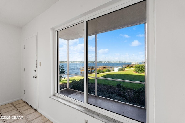 doorway featuring a water view and baseboards