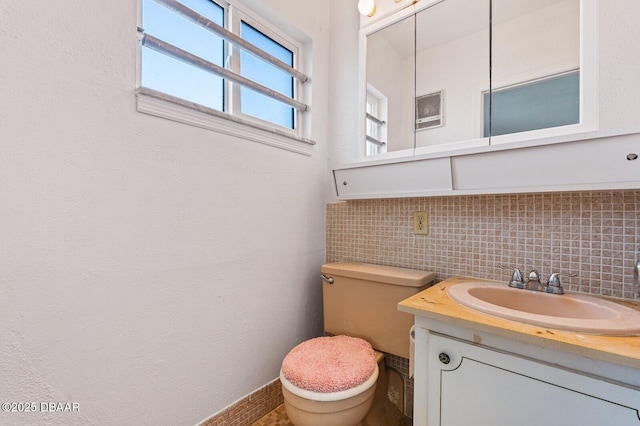 half bathroom with toilet, tasteful backsplash, and vanity