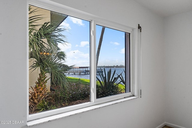 spare room featuring a water view and baseboards