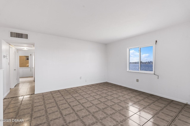 spare room featuring visible vents and baseboards