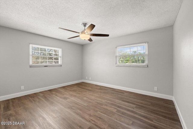 empty room with plenty of natural light, wood finished floors, and ceiling fan