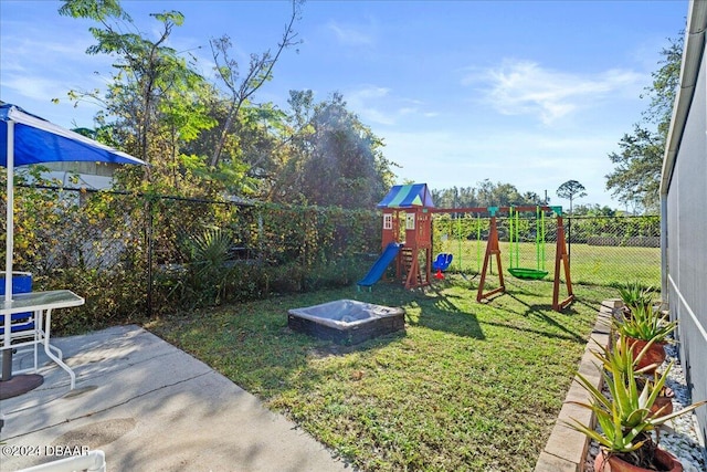 view of playground with a lawn, a patio, and a fenced backyard