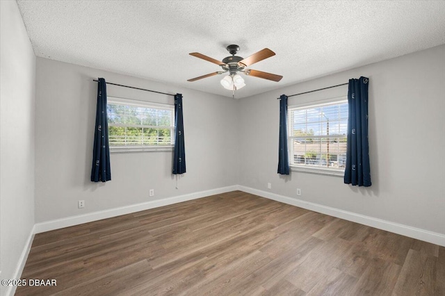 spare room with a textured ceiling, wood finished floors, baseboards, and ceiling fan