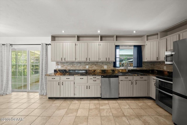 kitchen with tasteful backsplash, dark stone counters, recessed lighting, appliances with stainless steel finishes, and a sink