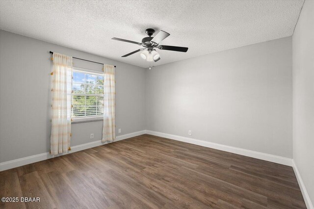 unfurnished room featuring ceiling fan, a textured ceiling, baseboards, and wood finished floors