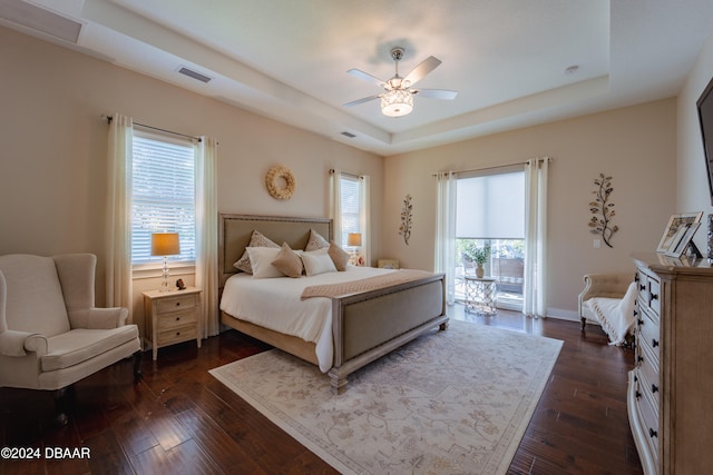 bedroom with ceiling fan, dark hardwood / wood-style flooring, and multiple windows