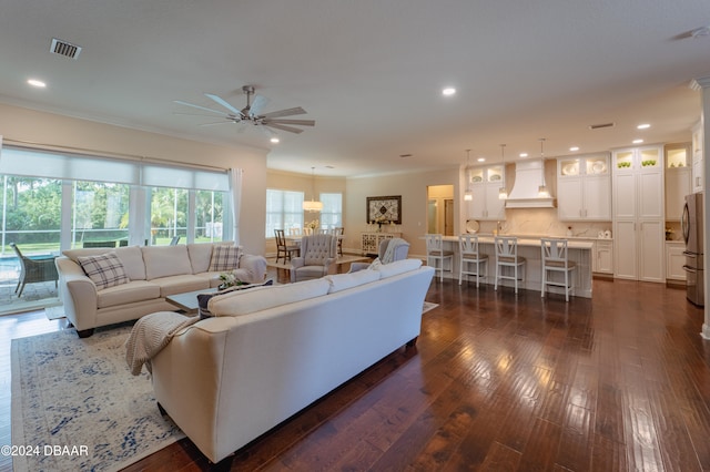 living room featuring ceiling fan, dark hardwood / wood-style flooring, and ornamental molding