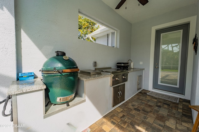 view of patio / terrace featuring sink, an outdoor kitchen, ceiling fan, and grilling area