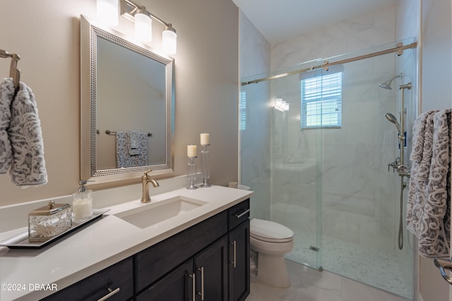 bathroom featuring a shower with door, vanity, and toilet