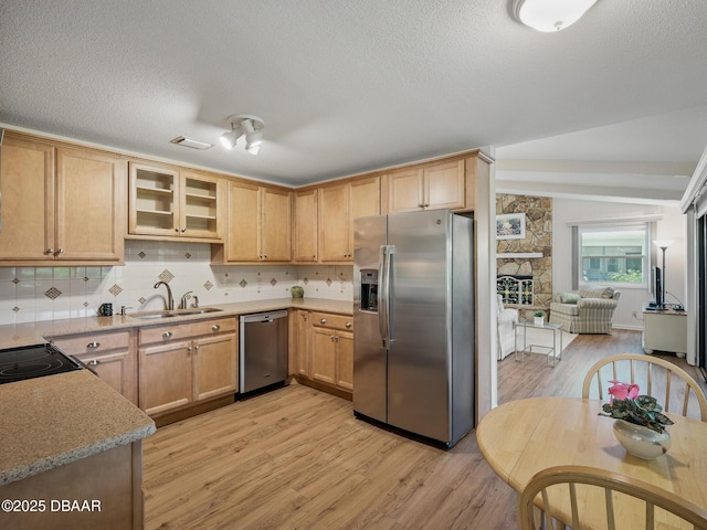 257 Sweet Bay Ave, New Smyrna Beach, FL 32168 - kitchen featuring appliances with stainless steel finishes, a sink, light wood-type flooring, tasteful backsplash, and a textured ceiling