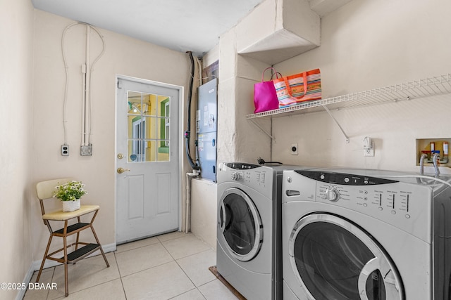 laundry room with washing machine and dryer and light tile patterned flooring