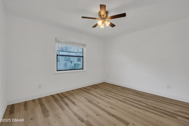 spare room featuring ceiling fan, light hardwood / wood-style flooring, and a textured ceiling