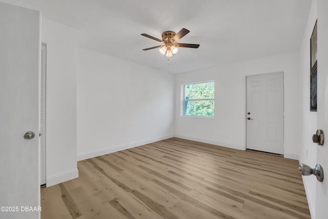 empty room with ceiling fan and light hardwood / wood-style floors