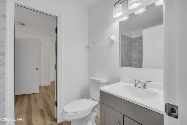 bathroom featuring toilet, vanity, and hardwood / wood-style flooring