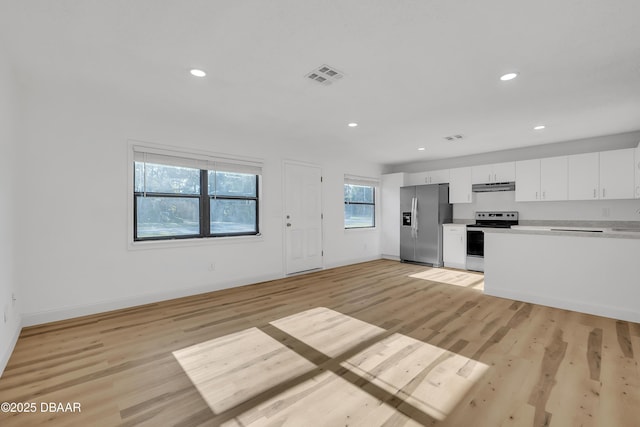 kitchen featuring light hardwood / wood-style floors, a healthy amount of sunlight, white cabinetry, and stainless steel appliances