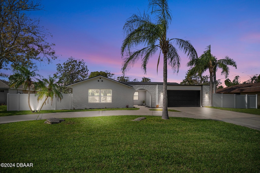 ranch-style home featuring a yard and a garage