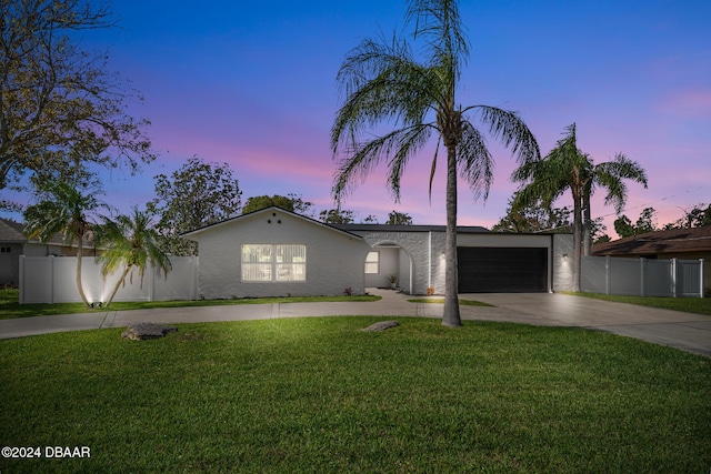 ranch-style home featuring a yard and a garage