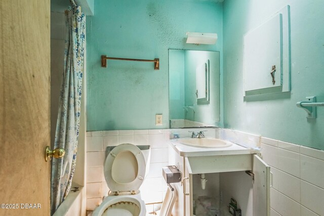 4519 Saxon Dr, New Smyrna Beach, FL 32169 - bathroom with tile walls, shower / bath combination with curtain, and wainscoting
