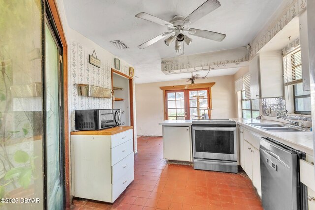 4519 Saxon Dr, New Smyrna Beach, FL 32169 - kitchen featuring stainless steel appliances, a peninsula, white cabinets, and light countertops