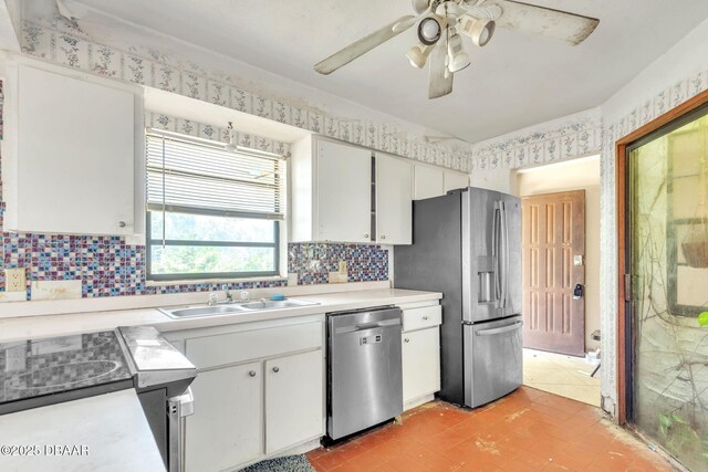 4519 Saxon Dr, New Smyrna Beach, FL 32169 - kitchen with appliances with stainless steel finishes, light countertops, ceiling fan, backsplash, and white cabinetry