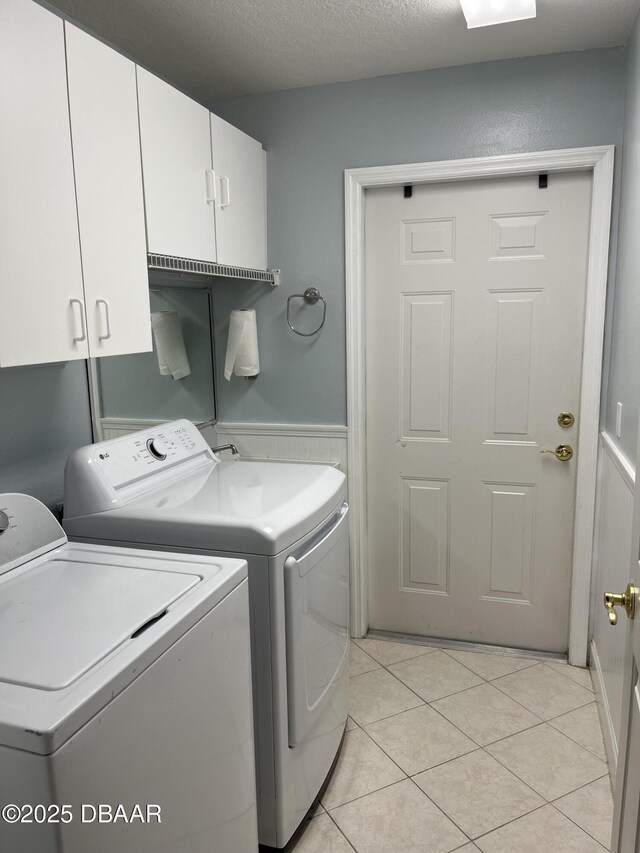 5988 Heron Pond Dr, Port Orange, FL 32128 - washroom featuring independent washer and dryer, cabinet space, light tile patterned flooring, and wainscoting