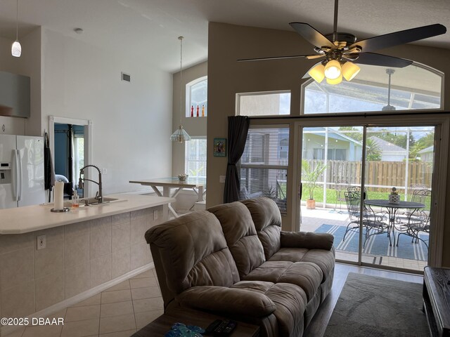 5988 Heron Pond Dr, Port Orange, FL 32128 - living area with tile patterned floors, high vaulted ceiling, and ceiling fan