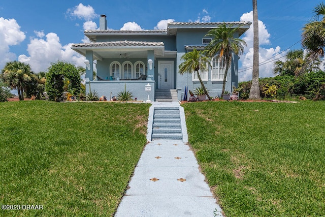 view of front of home with covered porch and a front yard