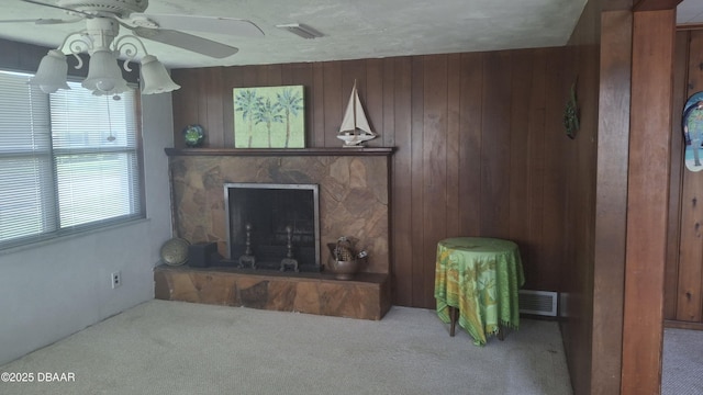 179 Ponce De Leon Dr, Ormond Beach, FL 32176 - carpeted living room with a stone fireplace, ceiling fan, and wood walls