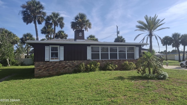 179 Ponce De Leon Dr, Ormond Beach, FL 32176 - single story home with brick siding, a front yard, and a chimney