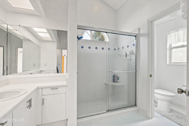 bathroom with toilet, vanity, tile patterned flooring, and a stall shower