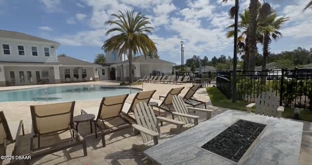 view of swimming pool with an outdoor fire pit and a patio