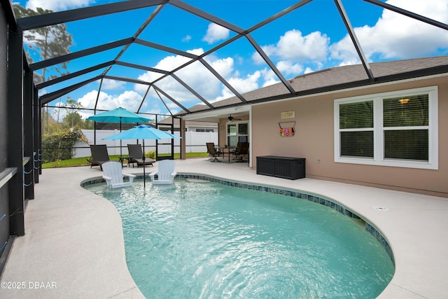 view of swimming pool with a patio, glass enclosure, and ceiling fan