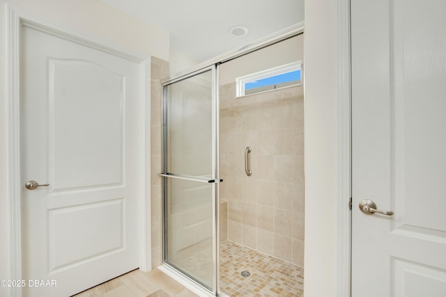 bathroom with a shower with door