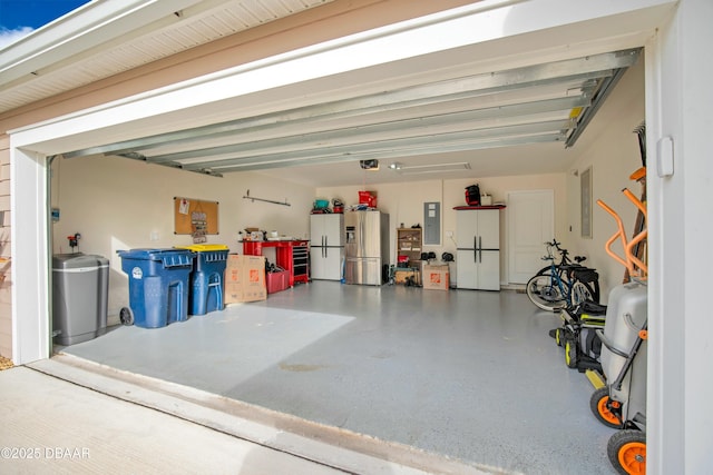 garage featuring stainless steel fridge, white refrigerator, and electric panel