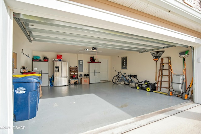garage featuring stainless steel refrigerator with ice dispenser, electric panel, and white fridge