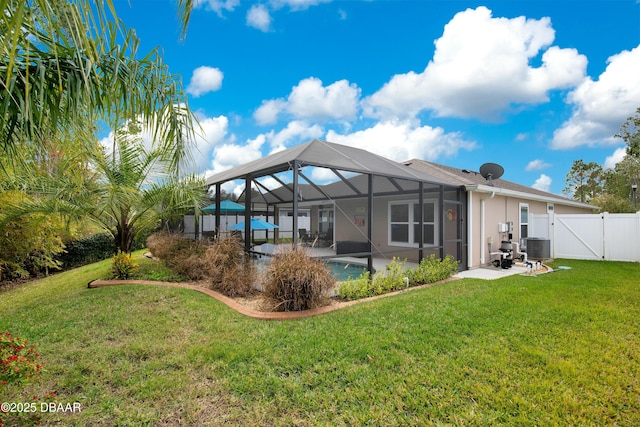 rear view of house featuring a patio area, a lanai, a lawn, and central AC