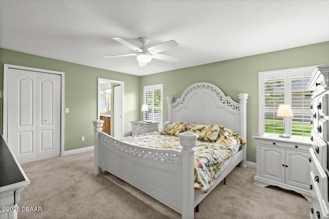 5935 Shady Creek Ln, Port Orange, FL 32128 - bedroom with light colored carpet, ensuite bath, baseboards, a textured ceiling, and a ceiling fan