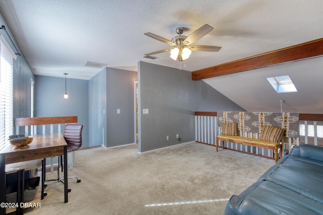 carpeted living room with a textured ceiling, ceiling fan, a healthy amount of sunlight, and vaulted ceiling with skylight