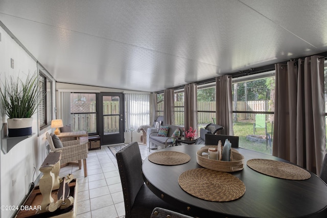 dining area featuring a wealth of natural light, light tile patterned floors, and a textured ceiling