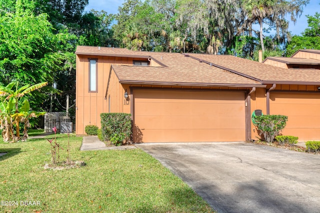 view of front of home with a garage and a front lawn