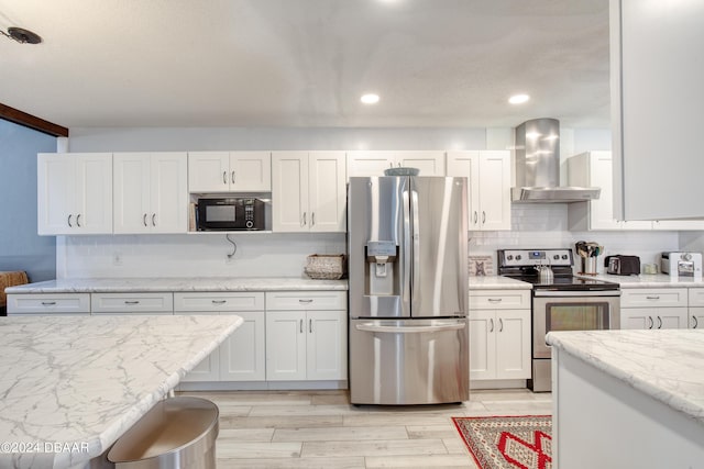 kitchen with backsplash, wall chimney exhaust hood, light stone countertops, white cabinetry, and stainless steel appliances