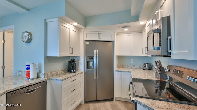 2625 S Atlantic Ave Unit 18Sw, Daytona Beach, FL 32118 - kitchen with light stone countertops, white cabinetry, stainless steel appliances, and light wood-type flooring