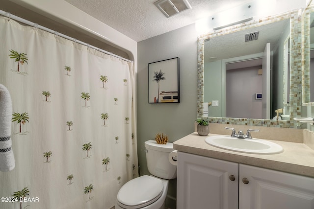 bathroom featuring vanity, a textured ceiling, and toilet