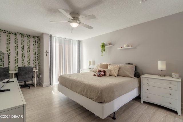 bedroom featuring a textured ceiling, light hardwood / wood-style floors, and ceiling fan