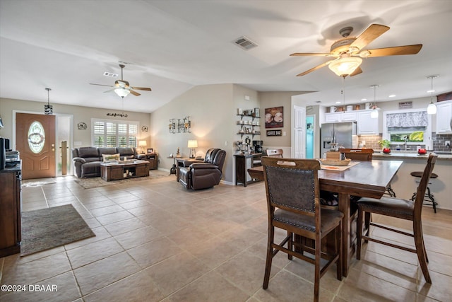 tiled dining area with vaulted ceiling and ceiling fan