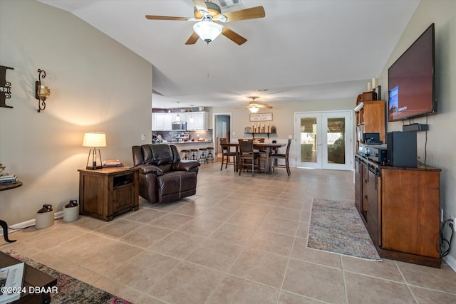 living room with lofted ceiling, french doors, light tile patterned floors, and ceiling fan