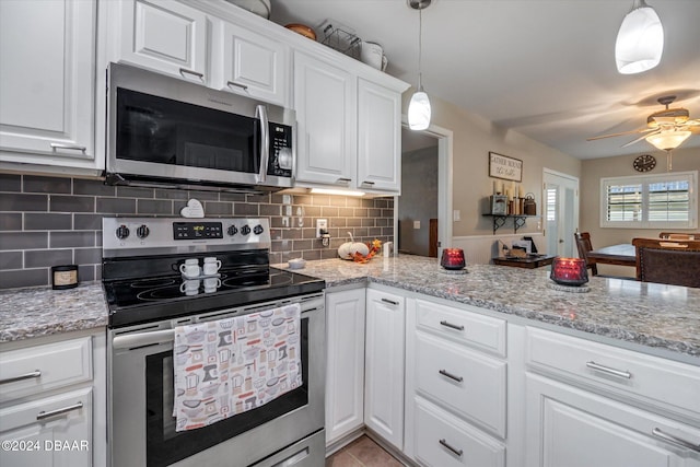 kitchen featuring white cabinets, stainless steel appliances, tasteful backsplash, and pendant lighting